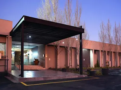 a building with a black canopy in a parking lot at Q's Evander Hotel & Apartments in Evander