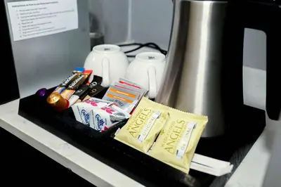 a shelf with toothpaste and toothbrushes and a blender at Q's Evander Hotel & Apartments in Evander