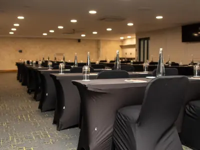 a row of tables and chairs in a conference room at Q's Evander Hotel & Apartments in Evander