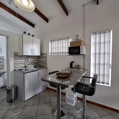 a kitchen with a table and a counter top at Sleep Haven Self-Catering Accommodation - Nelspruit in Nelspruit