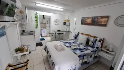 a bedroom with a bed and a table in it at Sleep Haven Self-Catering Accommodation - Nelspruit in Nelspruit