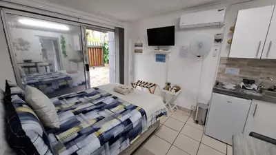 a small bedroom with a bed and a kitchen at Sleep Haven Self-Catering Accommodation - Nelspruit in Nelspruit