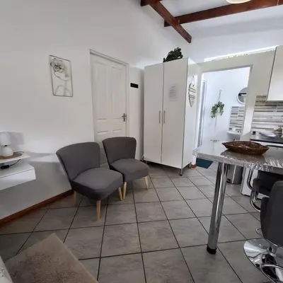 a kitchen with two chairs and a table at Sleep Haven Self-Catering Accommodation - Nelspruit in Nelspruit