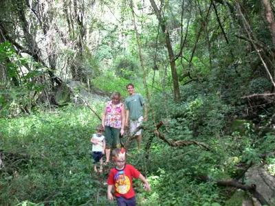a family walking on a trail in the woods at Magoebaskloof Getaway in Magoebaskloof