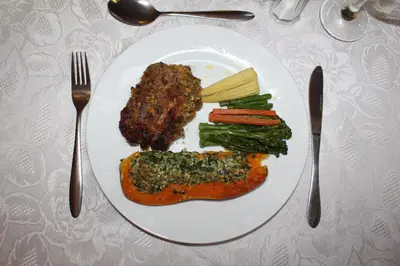 a plate of food with meat and vegetables on a table at Magoebaskloof Getaway in Magoebaskloof