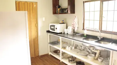 a kitchen with a sink and a microwave at Magoebaskloof Getaway in Magoebaskloof