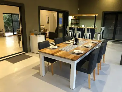 a dining room table with chairs and a kitchen at Modern Bush Living in Marloth Park
