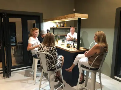 a group of people sitting at a bar at Modern Bush Living in Marloth Park