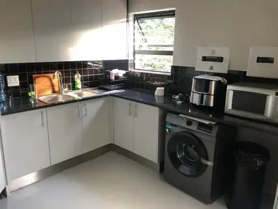 a kitchen with a sink and a washing machine at Modern Bush Living in Marloth Park