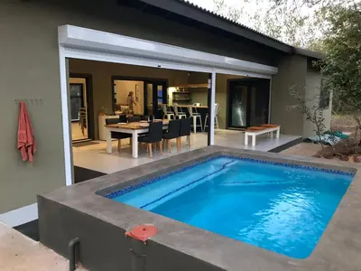 a swimming pool in the backyard of a house at Modern Bush Living in Marloth Park