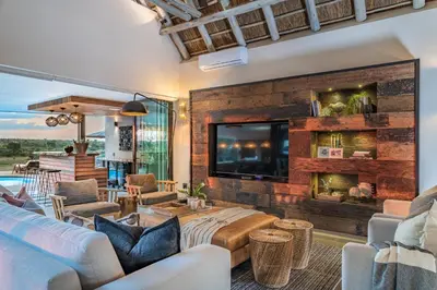 a living room with a fireplace and a tv at Marula Sunrise Lodge, Mjejane Private Game Reserve in Hectorspruit