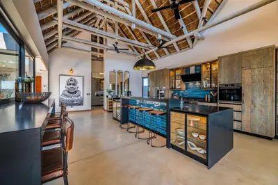 an open kitchen with wooden cabinets and a large island at Marula Sunrise Lodge, Mjejane Private Game Reserve in Hectorspruit