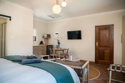 a bedroom with a bed and a living room at The Lofts @ Maple Square in Dullstroom