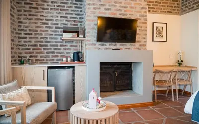 a living room with a fireplace and a table at The Lofts @ Maple Square in Dullstroom