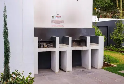 a white wall with two tables against a building at Luminant Escapes -With Power Backup in Midrand