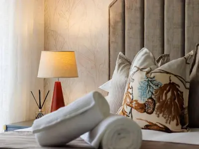 a bedroom with a bed with a lamp and pillows at Luminant Escapes -With Power Backup in Midrand