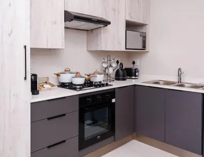 a kitchen with a stove top oven next to a sink at Luminant Escapes -With Power Backup in Midrand