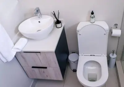 a bathroom with a white sink and a toilet at Luminant Escapes -With Power Backup in Midrand