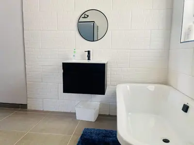 a bathroom with a sink and a tub and a mirror at TrendyBliss Guest House in Northam