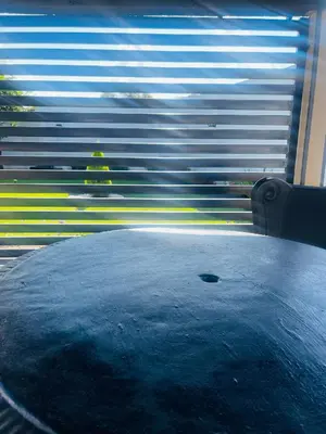 a table in front of a window with blinds at TrendyBliss Guest House in Northam