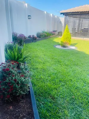 a yard with flowers and plants in the grass at TrendyBliss Guest House in Northam
