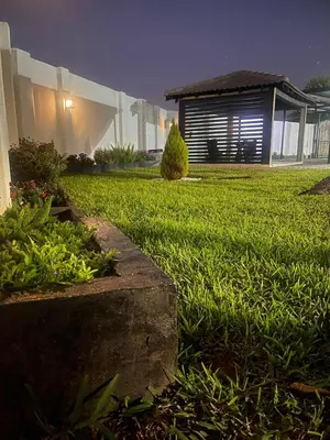 a house with a yard with green grass and a building at TrendyBliss Guest House in Northam