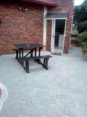 a picnic table in front of a brick building at Anglerfish in Centurion