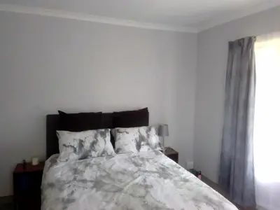a bedroom with a bed and a window at Anglerfish in Centurion