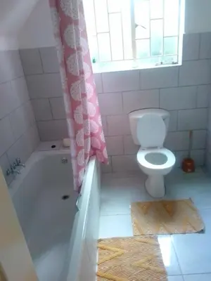 a bathroom with a toilet and a tub and a sink at Anglerfish in Centurion