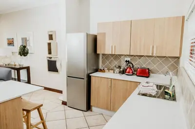 a kitchen with a stainless steel refrigerator and cabinets at Filmerton Country Lodge in Kyalami
