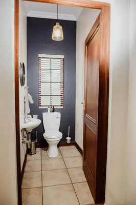 a bathroom with a toilet and a sink at Filmerton Country Lodge in Kyalami