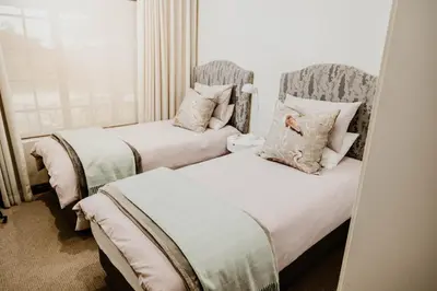 two beds sitting next to each other in a bedroom at Filmerton Country Lodge in Kyalami