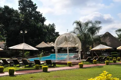 a pool with chairs and a gazebo next to a resort at 2Ten Hotel in Sibasa