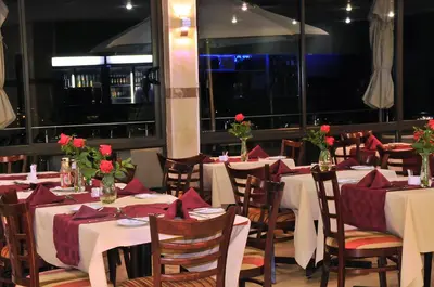 a dining room with tables and chairs with red napkins at 2Ten Hotel in Sibasa