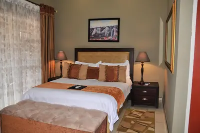a bedroom with a large bed and a couch at 2Ten Hotel in Sibasa