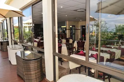 a restaurant with tables and chairs on a balcony at 2Ten Hotel in Sibasa