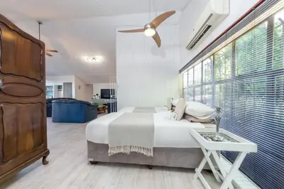 a bedroom with a bed and a large window at Fralande Self Catering Units in Pretoria