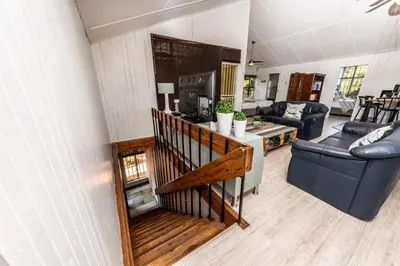 a living room with a staircase in a house at Fralande Self Catering Units in Pretoria