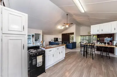a kitchen with white cabinets and a black stove at Fralande Self Catering Units in Pretoria