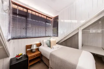a small bedroom with a bed and a window at Fralande Self Catering Units in Pretoria