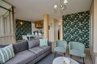 a living room with a couch and two chairs at Unit 406 at Menlyn Place in Pretoria