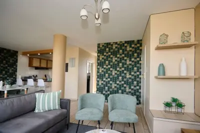 a living room with a couch and two chairs at Unit 406 at Menlyn Place in Pretoria