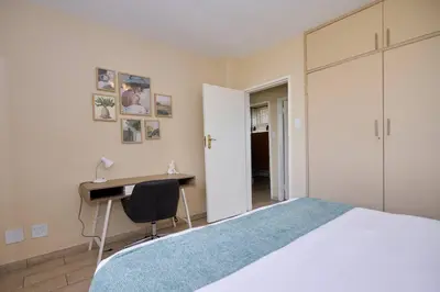 a bedroom with a bed and a desk and a desk at Unit 406 at Menlyn Place in Pretoria