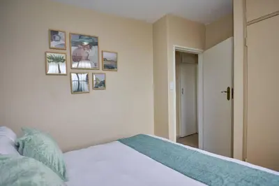 a bedroom with a bed and pictures on the wall at Unit 406 at Menlyn Place in Pretoria