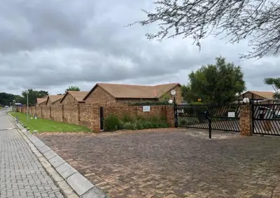 a brick house with a fence in front of it at Apartment@VillaVel in Midrand