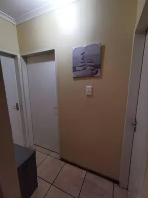 a bathroom with a door and a painting on the wall at Apartment@VillaVel in Midrand