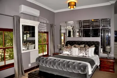a bedroom with a large bed and windows at Ambonnay Terrace Guest House in Pretoria