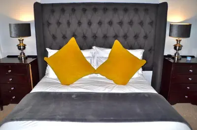 two yellow pillows on a bed with two night stands at Ambonnay Terrace Guest House in Pretoria