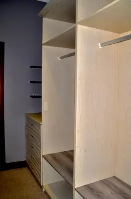a closet with wooden shelves next to a dresser at Ambonnay Terrace Guest House in Pretoria
