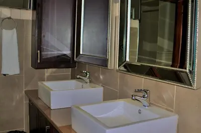 a bathroom with two sinks and a mirror at Ambonnay Terrace Guest House in Pretoria